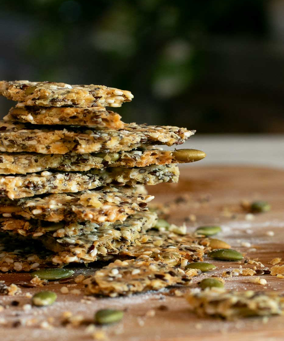 Seedy Olive Oil Crackers in a stack with Cockatoo Grove Extra Virgin Olive Oil