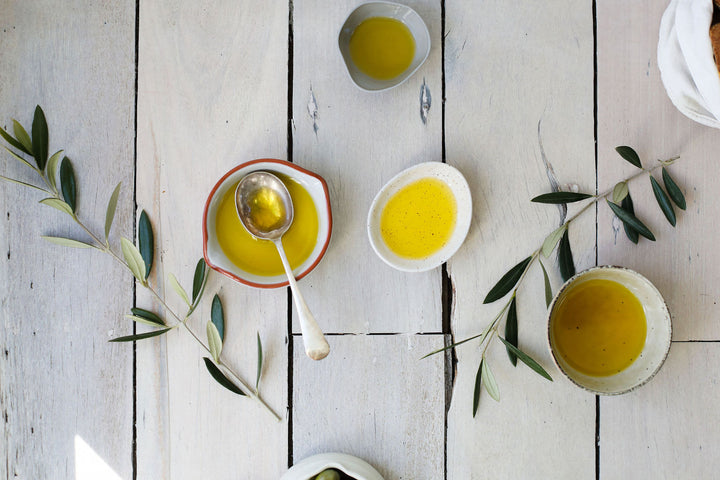 overhead image of several small bowls containing golden extra virgin olive oil